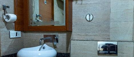 Un baño con lavabo, espejo, toallero, inodoro y ducha.