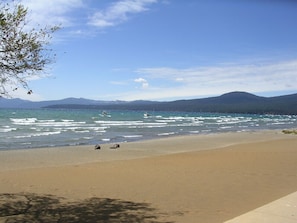 Enjoy a serene beach experience with a clear view of the surrounding mountains and forest.