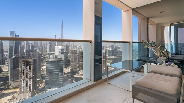 Un balcón moderno con barandilla de vidrio, que ofrece vistas a la ciudad.