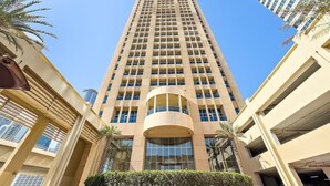 Un edificio alto color beige con una estructura cilíndrica central y varios pisos.