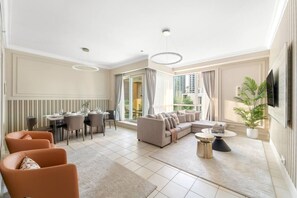 Relax in this stylish living area with a large sofa, dining table, and TV.