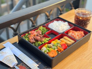 A bento box with various food items on a table. - Cozy Cubes (Ho Chi Minh City)