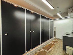 Een douche, designer toiletartikelen, een haardroger, pantoffels