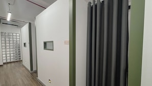 A hallway with a patterned wall, a small window, and a door with a decorative grille. - Cozy Cubes (Ho Chi Minh City)