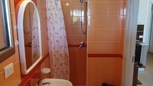 A bathroom with a sink, mirror, shower, and toilet. - Residence Lo Zodiaco (Lampedusa)