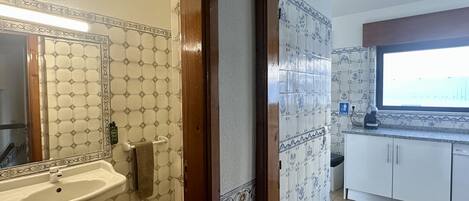 A bathroom with a sink, mirror, and towel rack.