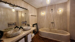Une salle de bain avec deux lavabos, une baignoire et une douche.