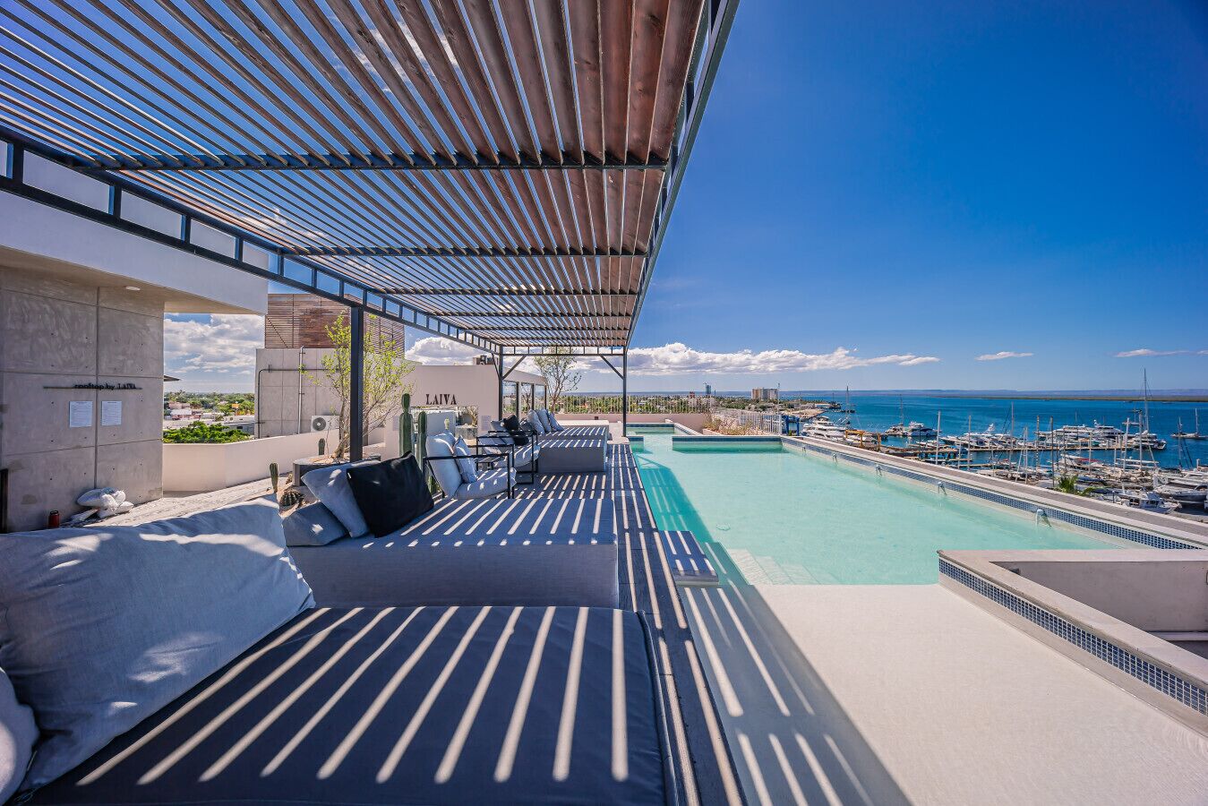 Piscina no terraço com vista para a marina e o oceano.