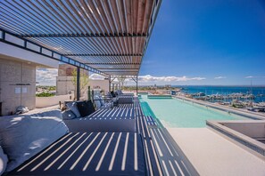 Piscina no terraço com vista para a marina e o oceano.