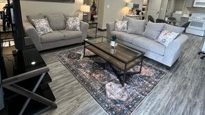 Un salon moderne avec deux canapés, une table basse et un téléviseur.