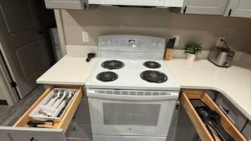 Una cocina compacta con microondas, estufa y cajones de almacenamiento integrados.