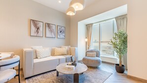 A modern living room with a sofa, a round coffee table, and a potted plant.