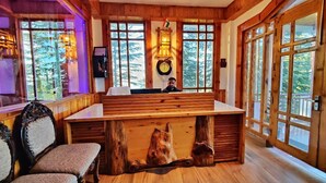 Un interior de madera con una recepción, ventanas amplias y un reloj en la pared.