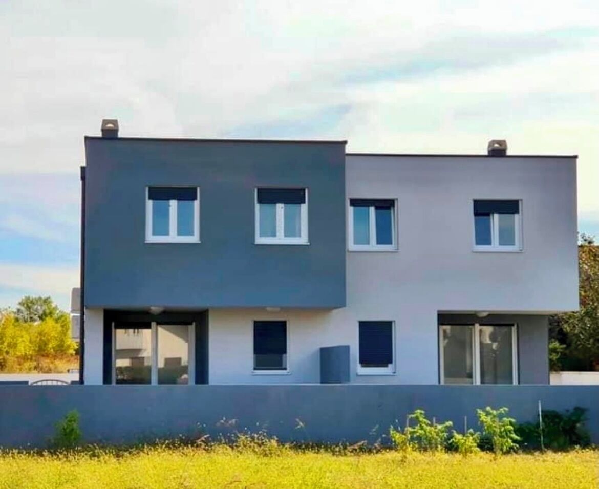Un bâtiment moderne à deux étages, doté de grandes fenêtres et d’un toit plat.