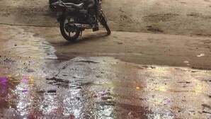 Un edificio con insegna da ristorante e hotel, una motocicletta parcheggiata e terreno bagnato.