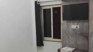 Una camera da letto con un letto, un armadio, una TV e un condizionatore d'aria.