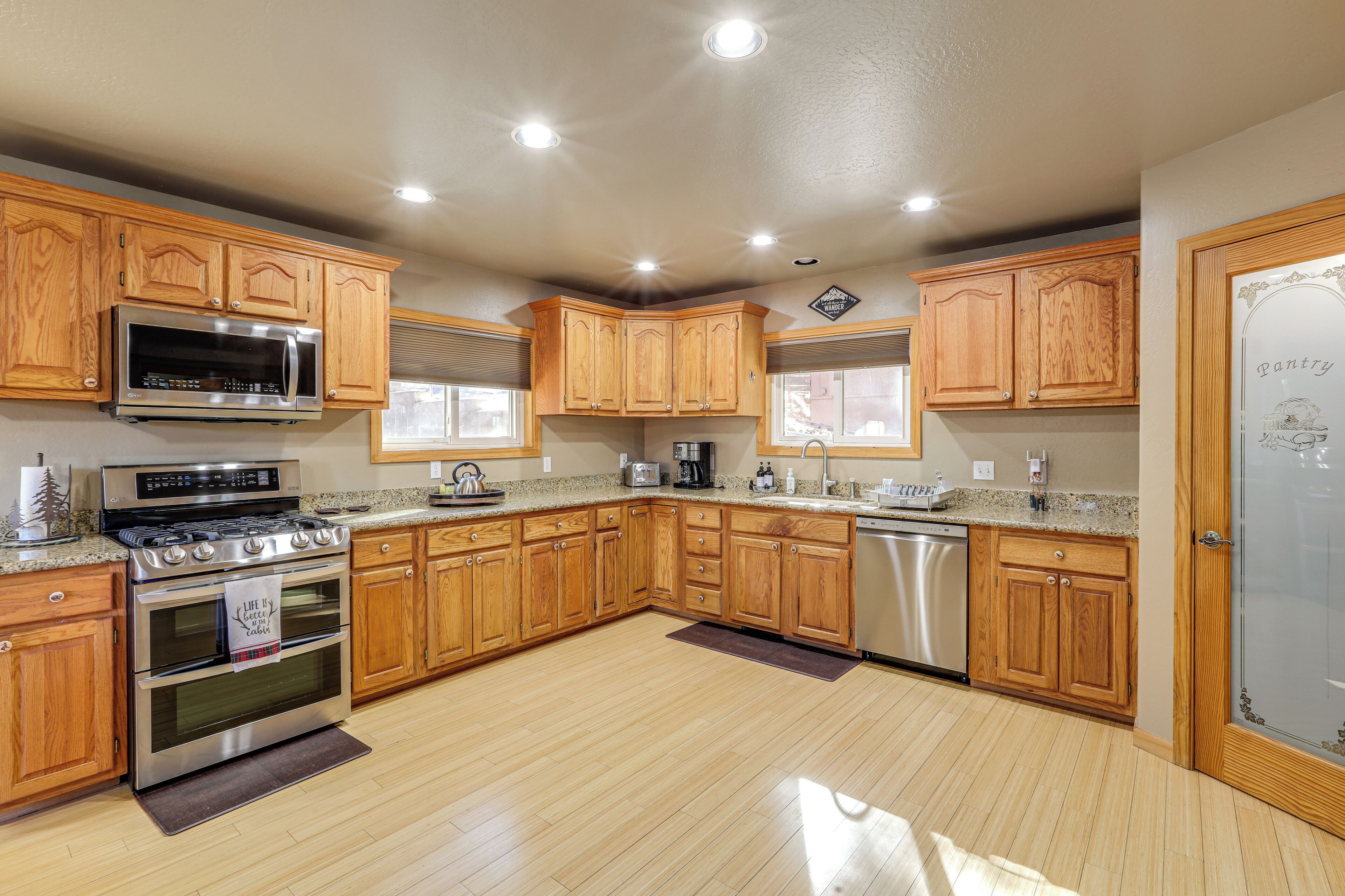 A spacious kitchen with wooden cabinets, stainless steel appliances, and a granite countertop.