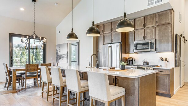 A modern kitchen with a central island, bar stools, pendant lighting, and stainless steel appliances. - Near Hiking & Biking: Winter Park Mtn-view Haven! (Winter Park)