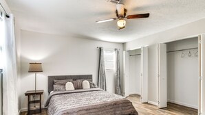 A bedroom with a bed, bedside table, lamp, ceiling fan, and a walk-in closet. - 6 Mi to The Masters: Updated Home w/ Yard! (Augusta)