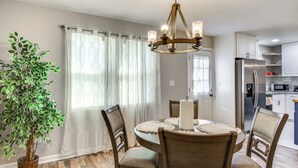 A dining area with a round table, chairs, a chandelier, and a potted plant. - 6 Mi to The Masters: Updated Home w/ Yard! (Augusta)