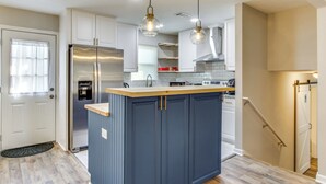 A modern kitchen with a central island, stainless steel appliances, and pendant lighting. - 6 Mi to The Masters: Updated Home w/ Yard! (Augusta)