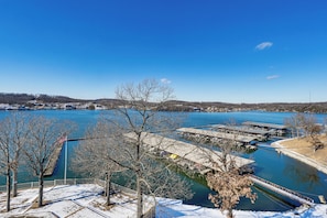 A waterfront property with a dock, a pier, and a snow-covered area with trees. - Boat, Swim & Enjoy Lake Views: Osage Beach Retreat (Osage Beach)