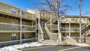 A multi-story motel with external staircases and a parking area with snow. - Boat, Swim & Enjoy Lake Views: Osage Beach Retreat (Osage Beach)