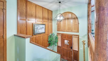 A wooden interior with a framed picture, a hanging light fixture, and a welcome sign.