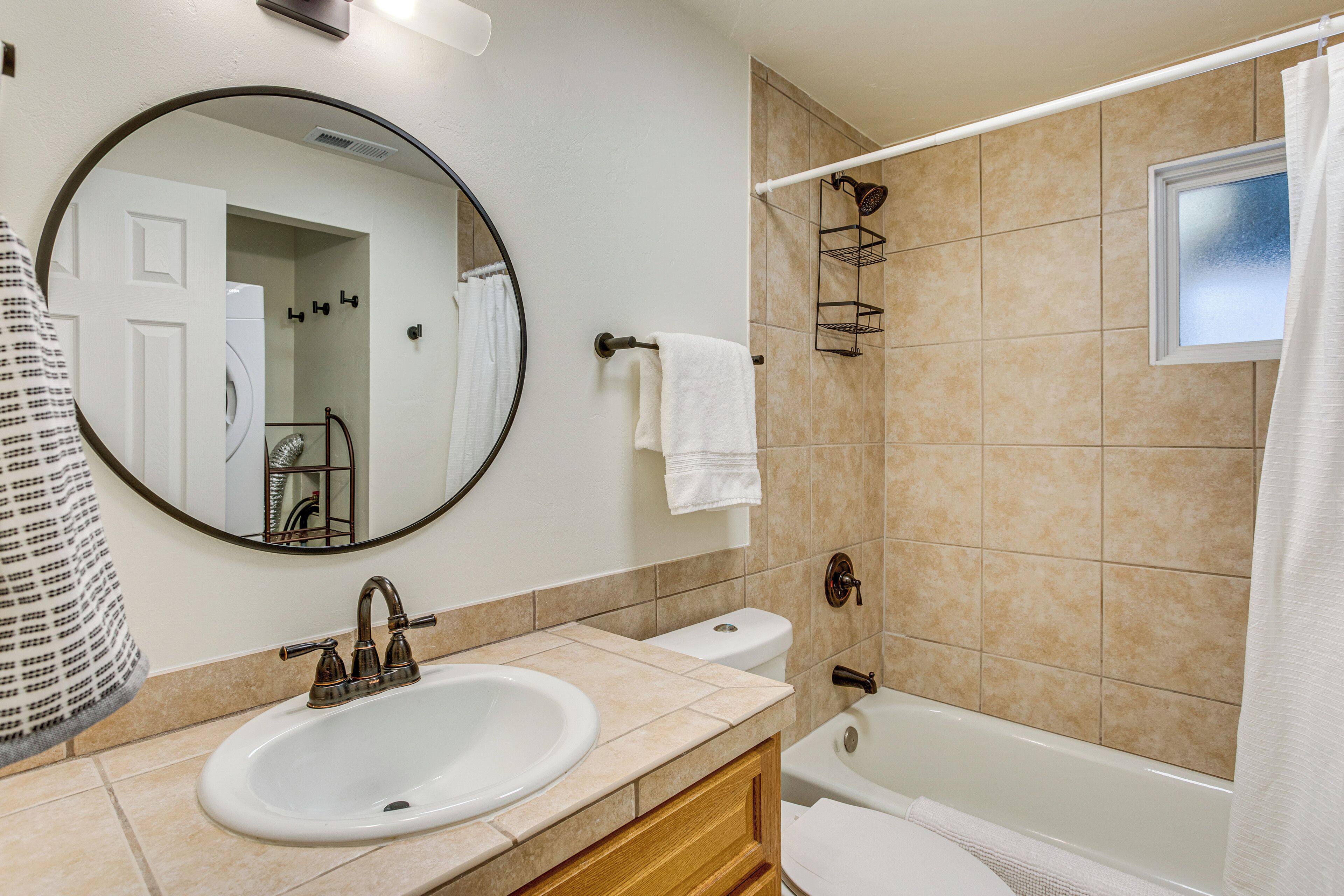 A bathroom with a sink, toilet, and bathtub.