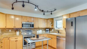 A modern kitchen with wooden cabinets, stainless steel appliances, and a central island. - Par & Powder: Avon Haven w/ Golf & Ski Access! (Avon)
