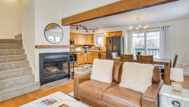 A modern living room with a fireplace, a leather sofa, and a dining area with wooden furniture. - Par & Powder: Avon Haven w/ Golf & Ski Access! (Avon)