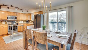 A modern kitchen with wooden cabinets, stainless steel appliances, and a dining area with a wooden table and chairs. - Par & Powder: Avon Haven w/ Golf & Ski Access! (Avon)