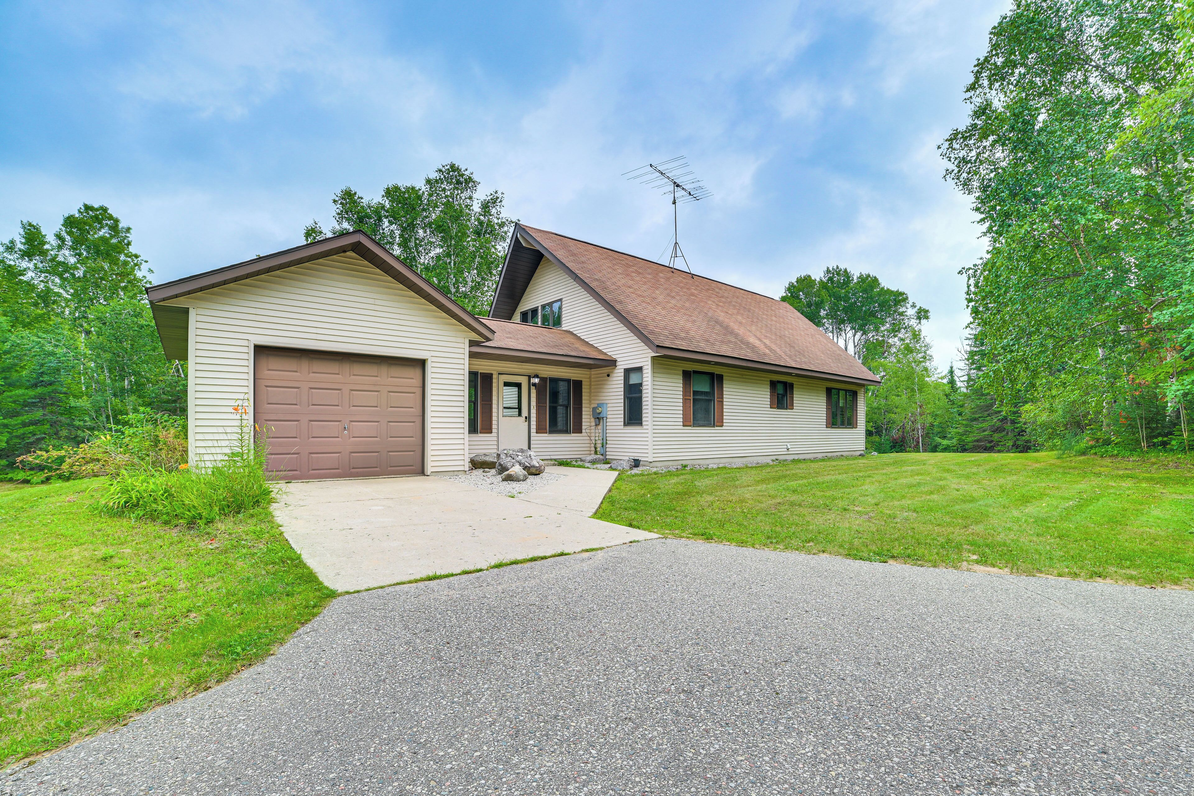 Ein zweistöckiges Haus mit Garage, Auffahrt und Rasen.