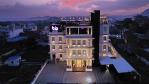 A multi-story hotel with a balcony and a sign that reads "bb". - THE COURTYARD - Beyond Bar & Club (Udaipur)