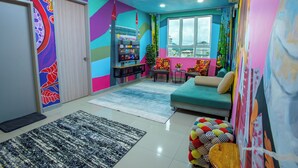 A vibrant living room with colorful walls, a sofa, a coffee table, and a TV.