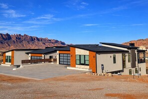 A modern building with a flat roof, large windows, and a stone facade. - Exclusive Retreats Desert Vista Retreat- Moab Estate for Large Groups- Pool, Spa (Moab)