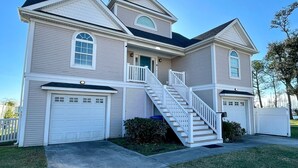 A two-story house with a front porch, a staircase, and a garage.