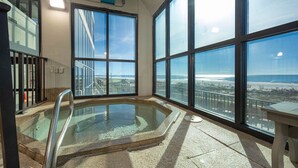 A large indoor swimming pool with a glass barrier, large windows, and a view of the beach. - Phoenix Iii 3084 2 Bedroom Condo (Orange Beach)