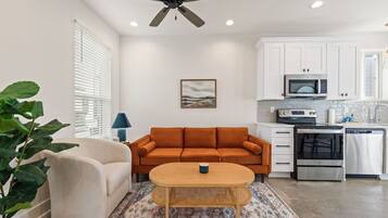 A modern living room with a sofa, a coffee table, and a potted plant.