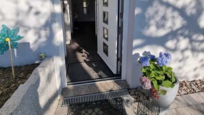 A house entrance with a door leading to a hallway, a mailbox, and a potted plant with flowers. - Holiday Apartment Moises y Ruth with beautiful garden (Murg)
