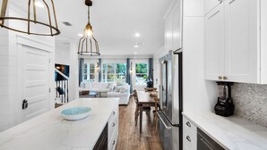 A modern kitchen with white cabinetry, a marble countertop, and a built-in refrigerator. - Pool, golf cart, nearby attractions & beach + Free Attraction Tickets! (Santa Rosa Beach)