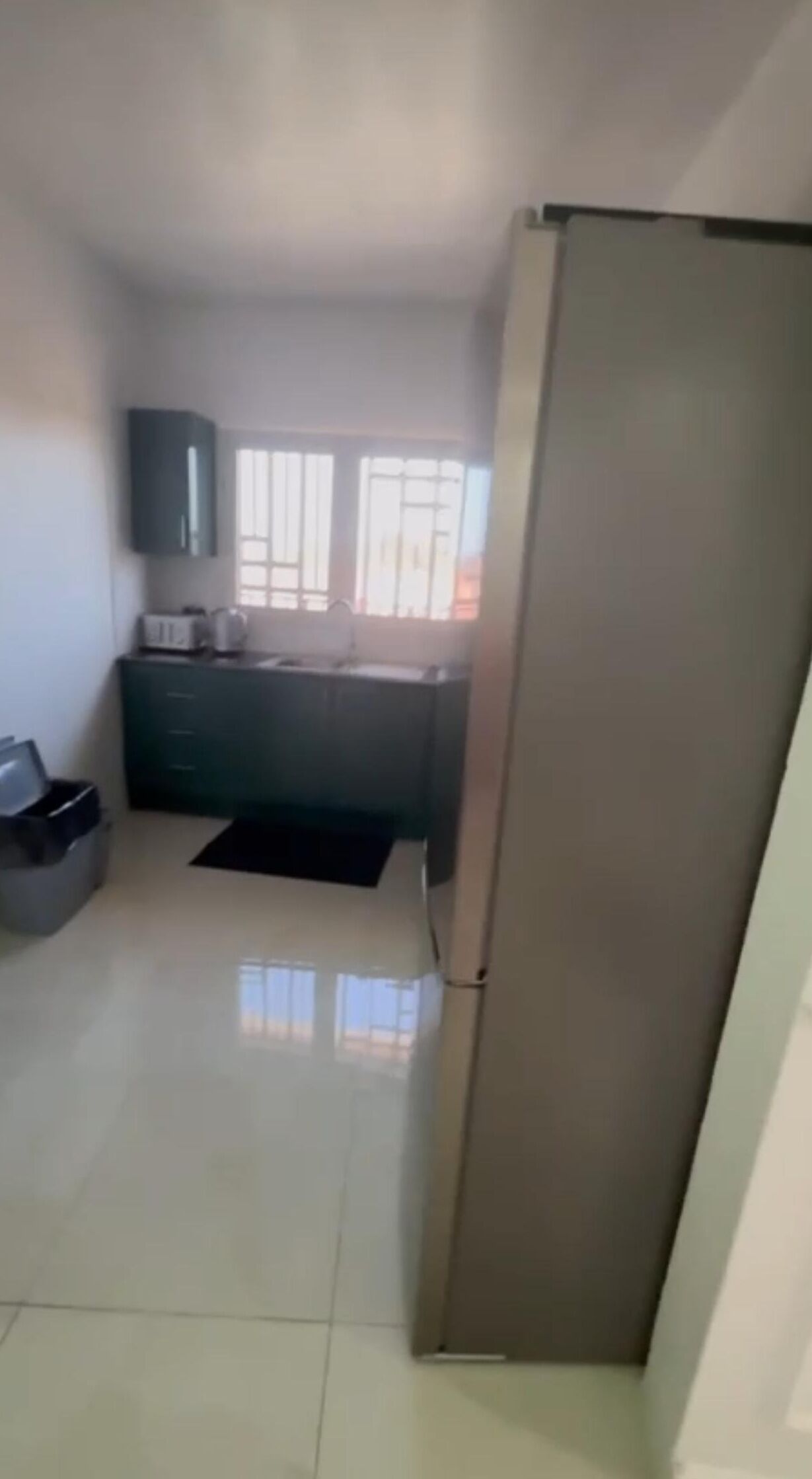 A kitchen with a refrigerator, a microwave, and a sink.