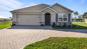 A single-story house with a garage, a front entrance, and a small porch area.