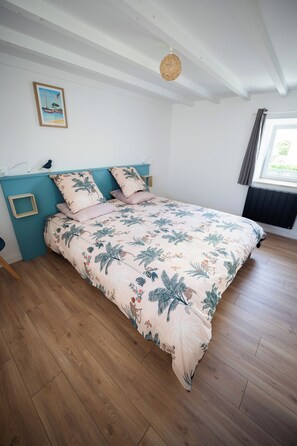 A bedroom with a bed, a picture on the wall, and a window with curtains. - Authentic, bright farmhouse—200 meters from the beach, the GR34 trail, and town (Plounéour-Brignogan-plages)