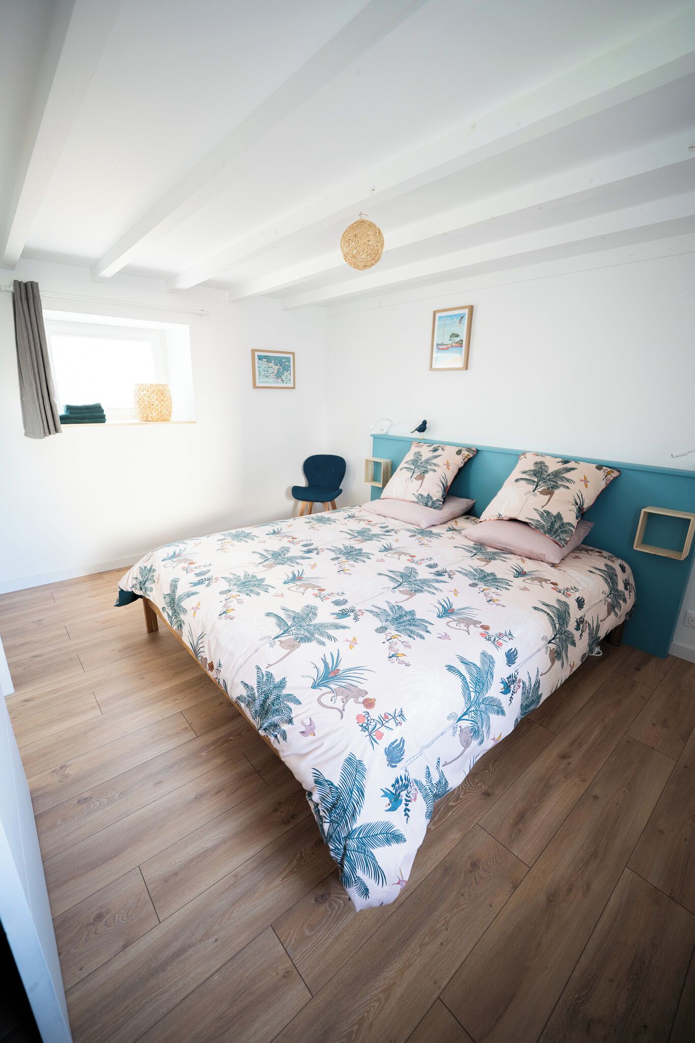 Ein Schlafzimmer mit einem Bett, einem Sessel und einem Fenster.