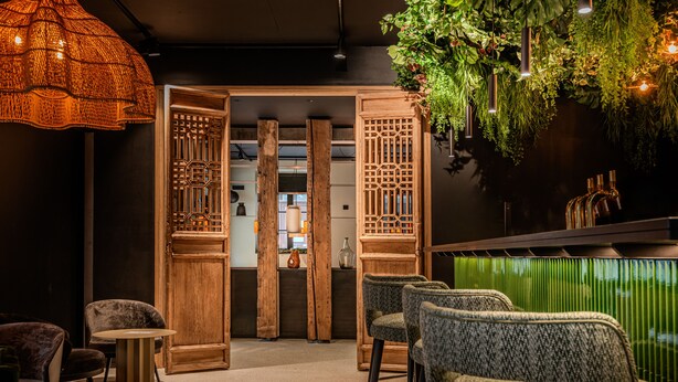 A modern interior with a bar area, wooden partitions, and green plants. - Appartements d'Anne - Saint Malo (Saint-Malo)