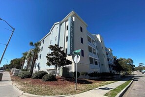 Un edificio de varios pisos con un cartel llamativo que dice 'Blue Beach Village'.