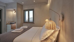 Un dormitorio moderno con una cama grande, una lámpara de noche y una ventana con vistas.