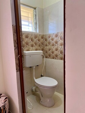 bathroom with a toilet, bathtub, and window.