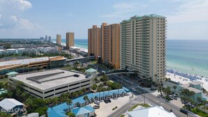 Un paisaje urbano costero con edificios altos, un puerto deportivo y una playa.